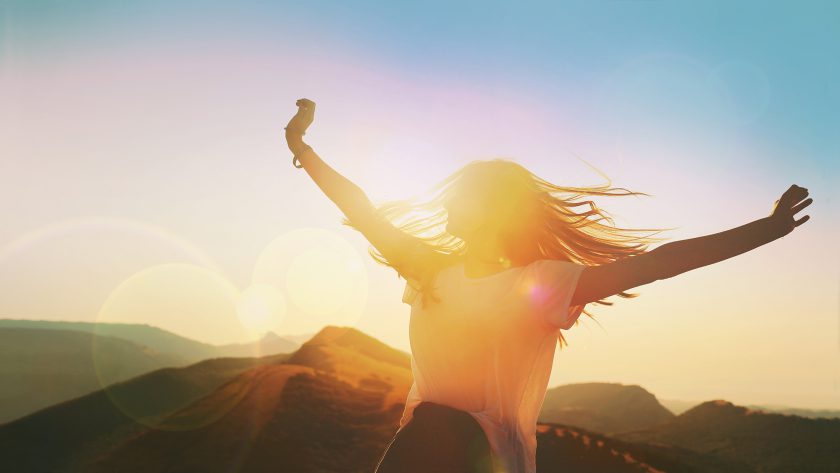 Woman celebrating with outstretched arms.