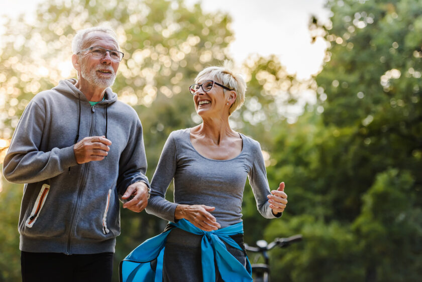 Photo of an elderly couple smiling and running. Used as the feature image for an article about musculoskeletal diseases and disorders.