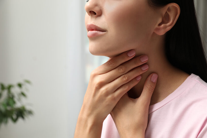 Closeup of young woman examining her thyroid.